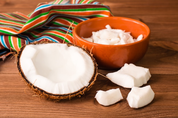 Noix de coco hachée et pulpe de noix de coco dans un bol sur une table en bois