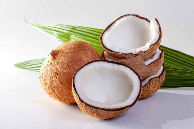 Noix de coco et huile de noix de coco sur fond blanc.