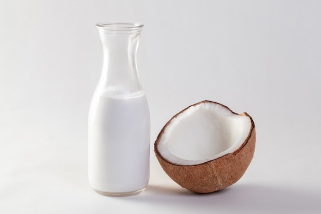 Noix de coco et huile de noix de coco sur fond blanc.