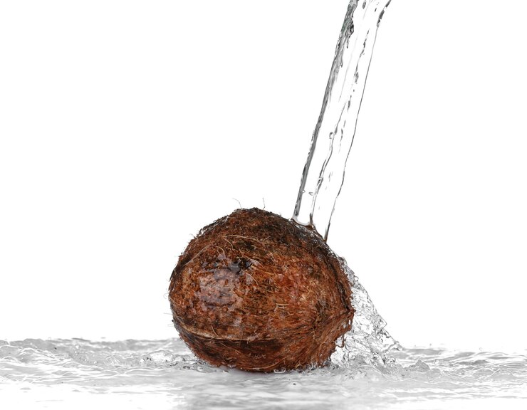 Photo noix de coco avec jet d'eau sur fond blanc