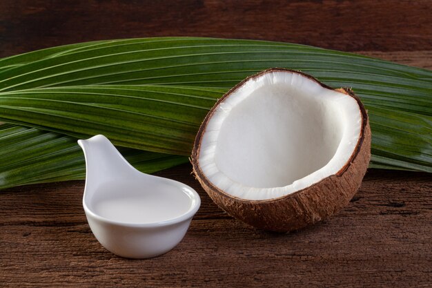 Noix de coco et lait de coco sur fond en bois.