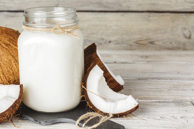 Noix de coco et lait de coco sur une table en bois rustique