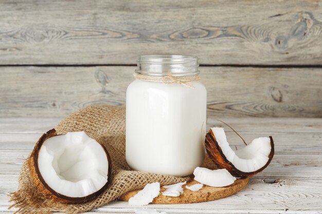 Noix de coco et lait de coco sur une table en bois rustique