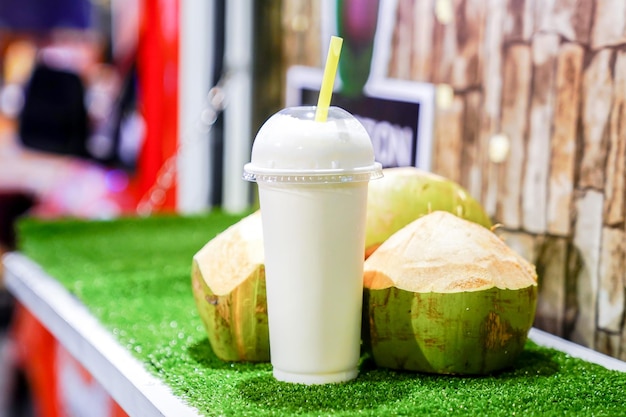 Noix de coco mélangée avec du lait prêt à boire en attente à l'avant de la vraie noix de coco