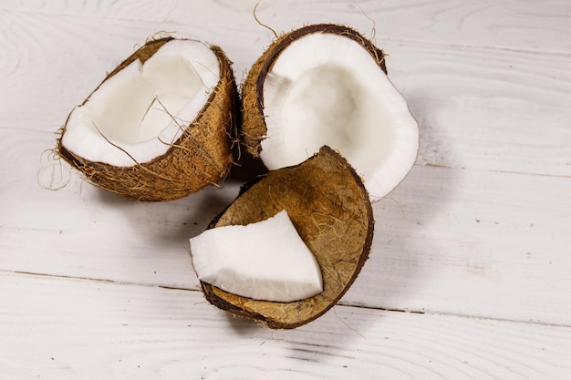 Noix de coco mûre fraîche sur une table en bois blanche