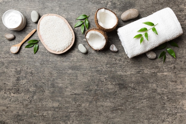 Noix de coco avec pots d'huile de noix de coco et crème cosmétique sur fond coloré Vue de dessus Espace libre pour votre texte Cosmétiques naturels à la noix de coco et concept de traitement biologique Composition du spa à la noix de coco