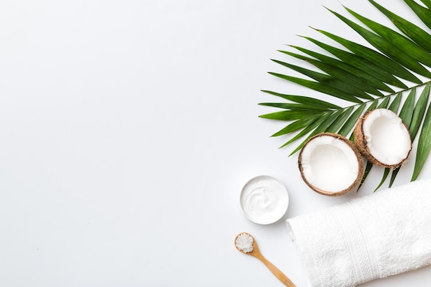 Noix de coco avec pots d'huile de noix de coco et crème cosmétique sur fond coloré Vue de dessus Espace libre pour votre texte Cosmétiques naturels à la noix de coco et concept de traitement biologique Composition du spa à la noix de coco