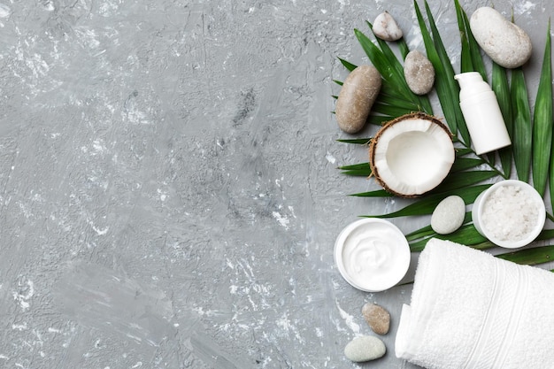 Noix de coco avec pots d'huile de noix de coco et crème cosmétique sur fond coloré Vue de dessus Espace libre pour votre texte Cosmétiques naturels à la noix de coco et concept de traitement biologique Composition du spa à la noix de coco