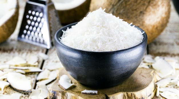 Noix de coco râpée, copeaux de noix de coco dans un bol en argile, ingrédient de cuisine