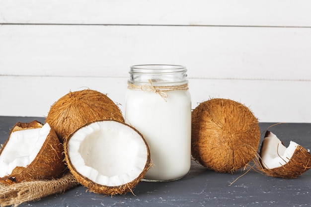 Noix de coco et verre de lait de coco sur fond de bois