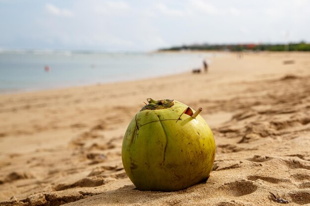 Noix de coco verte sur la plage au coucher du soleil