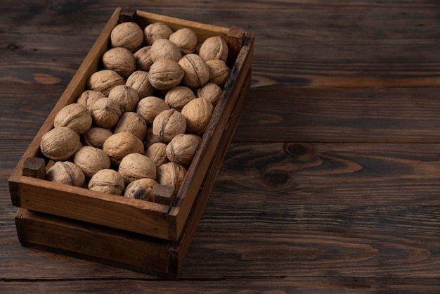 Noix dans une boîte en bois sur fond en bois