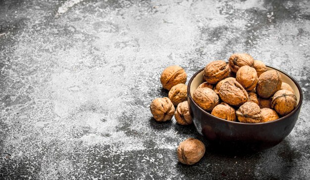 Les noix dans un bol sur table rustique.