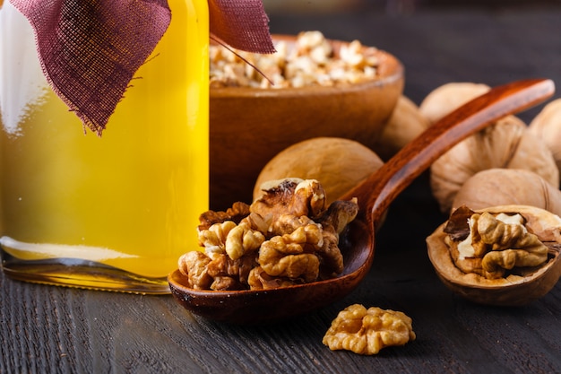 Noix entières avec une bouteille d'huile de noix vierge