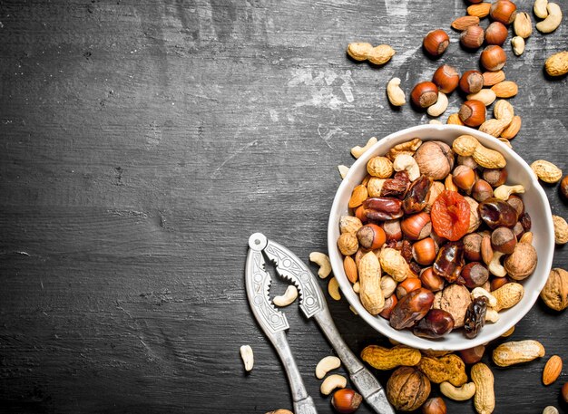 Noix et fruits secs dans un bol avec un casse-noisette.