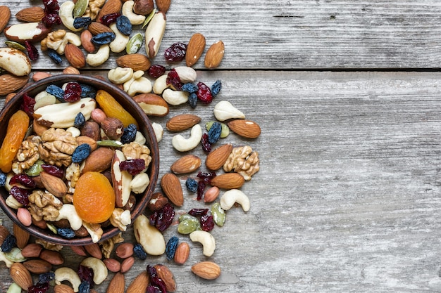 Noix et fruits secs dans un bol sur une table en bois rustique