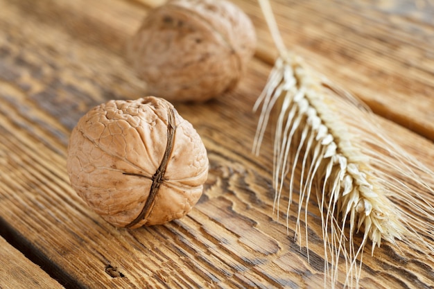 Noix de gros plan et épi de blé sur fond en bois. Faible profondeur de champ.