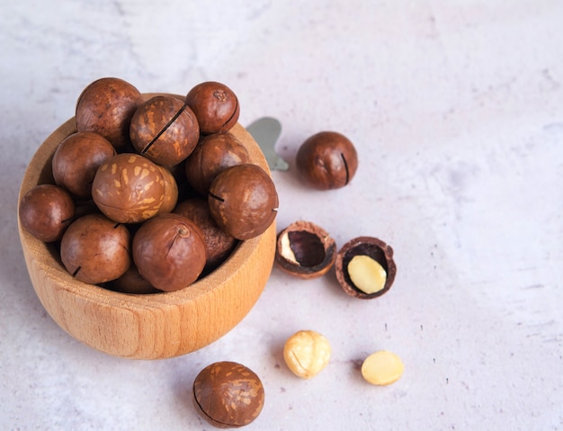 Noix de macadamia biologiques naturelles dans un bol en bois