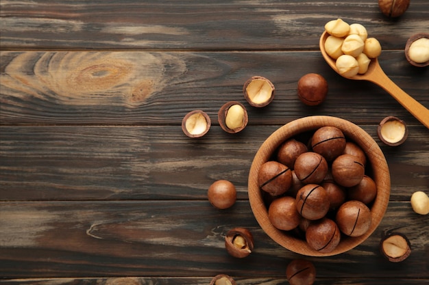 Noix de macadamia sur bol en bois sur fond marron Vue de dessus