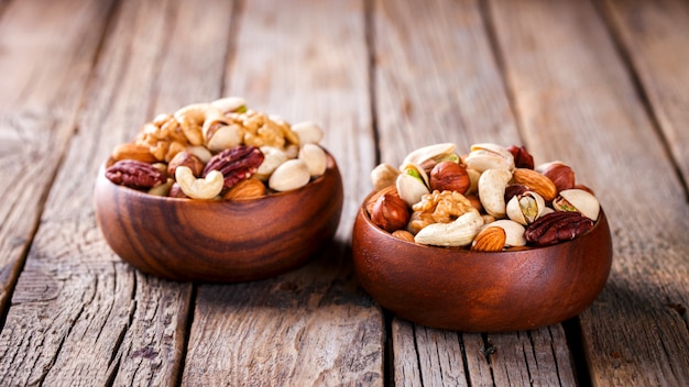 Noix mélangées dans une assiette en bois.assortiment