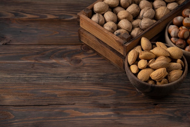 Noix mélangées noix amandes noix sur fond en bois dans un bol et une boîte