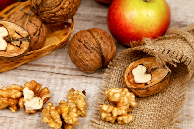 Noix et noyaux entiers sur une table avec des pommes