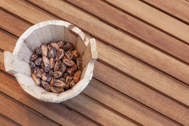 Les noix de pin dans un bol en bois sur table en bois