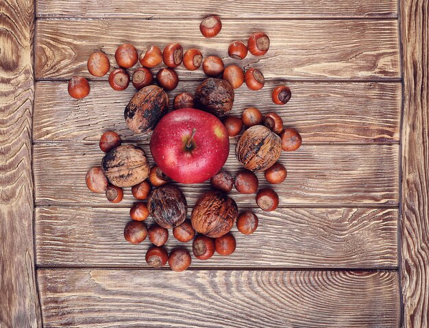 Noix Et Pomme Sur Une Table En Bois, Se Concentrer Sur La Pomme Au Centre