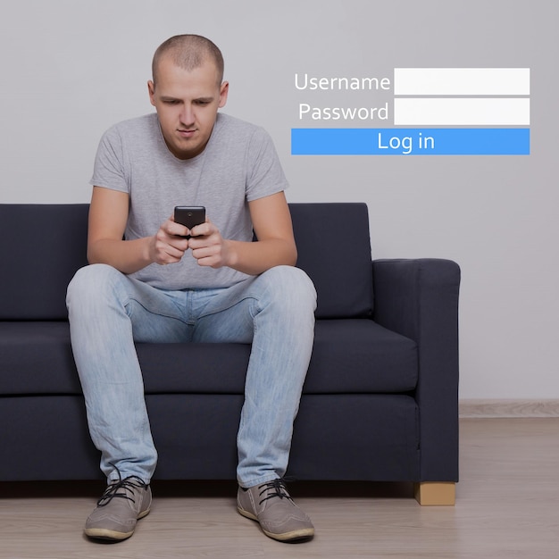 Nom d'utilisateur et mot de passe - jeune bel homme assis sur un canapé avec téléphone portable et panneau de connexion