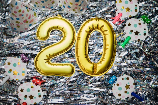 Photo le nombre 20 sur fond argenté date de vacances la figure est faite de feuille d'oranniversaire de vingt ans