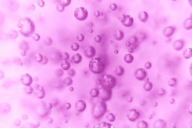 De nombreuses bulles rondes du gel douche sur fond violet