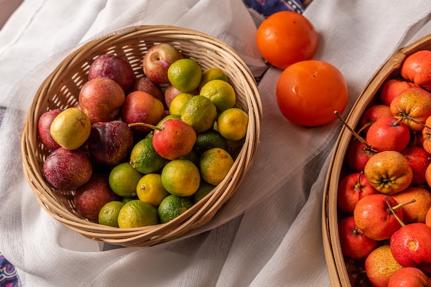 De nombreuses couleurs et variétés de fruits sont soit dans l'assiette, soit dispersées sur la table en bois