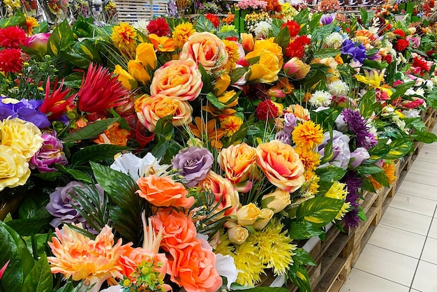 De nombreuses fleurs artificielles multicolores sur le comptoir du magasin