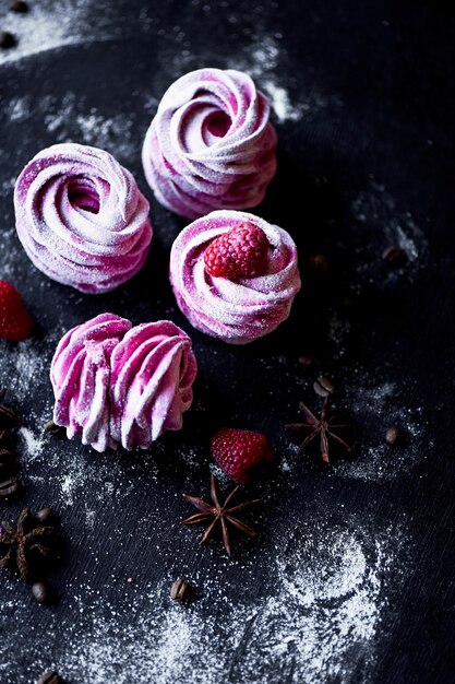 De nombreuses guimauves violettes sur une surface sombre Une image contrastée Une œuvre d'art culinaire