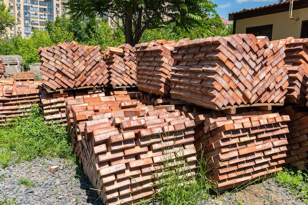 De nombreuses palettes de briques en céramique rouge sur un chantier de construction