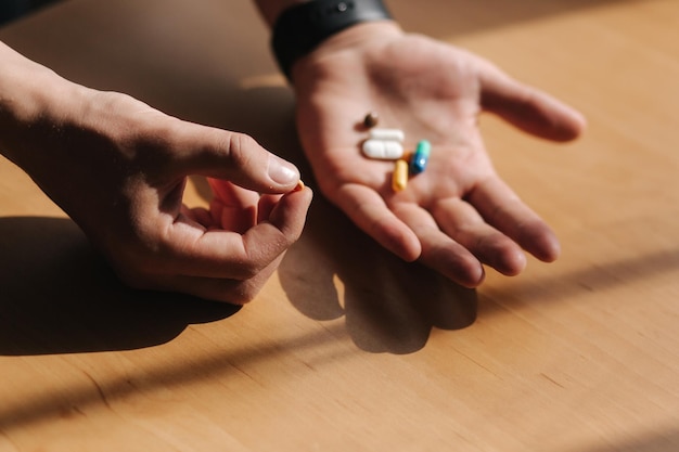 De nombreuses pilules multicolores sur les mains des hommes Homme avec montre à portée de main Concept de coronavirus