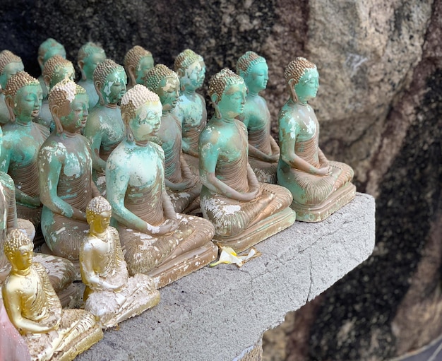 De nombreuses statues anciennes de Bouddha en pierre sont alignées en rangée.