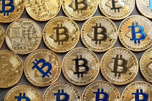 De nombreux bitcoins dorés sur fond gris