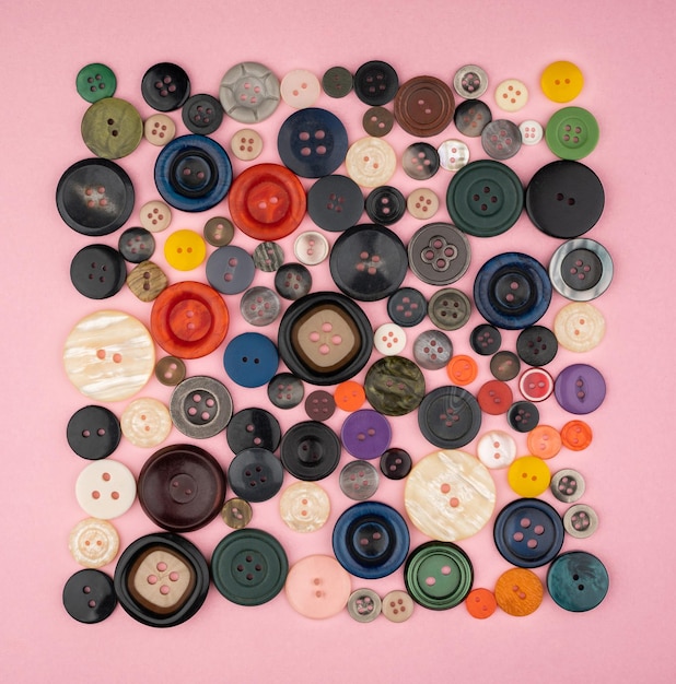 Photo de nombreux boutons différents sur fond rose