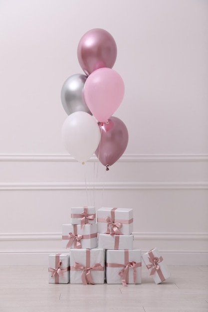 De nombreux coffrets cadeaux et ballons près du mur blanc dans la chambre