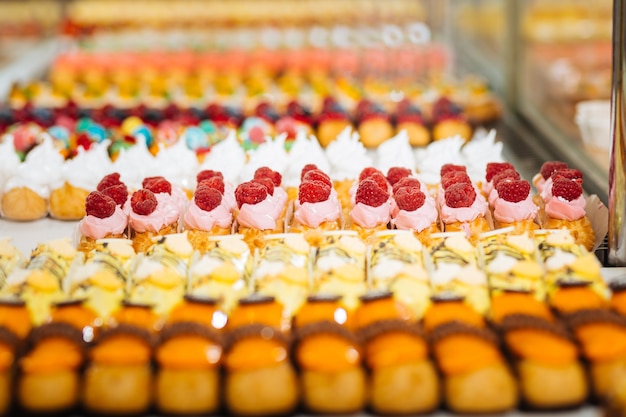 De nombreux éclairs. Vitrine avec un grand choix d'éclairs de fruits et de caramel