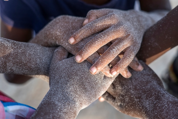 Photo de nombreux enfants africains mains se connectant sur la plage de sable, tanzanie, afrique