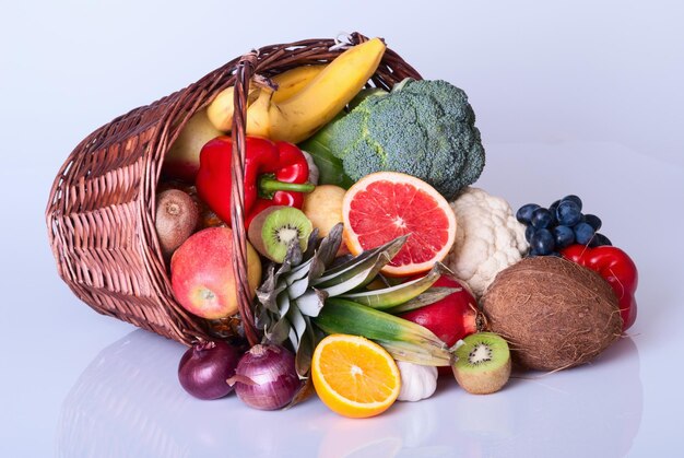 De nombreux fruits et légumes colorés frais dans le panier