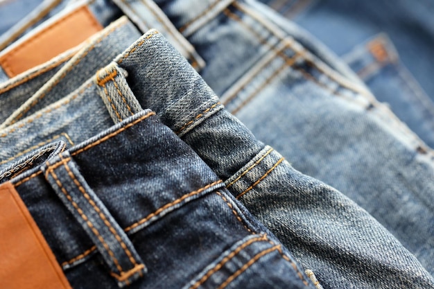 De nombreux jeans en pile dans la garde-robe Rangée de pantalons jeans en denim dans le placard Concept d'achat vente shopping et vêtements à la mode