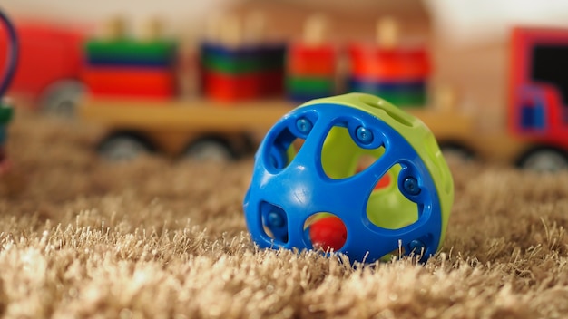 De nombreux jouets en bois pour bébés colorés sur un tapis de couleur marron clair qui comprennent un bus d'avion à billes et d'autres