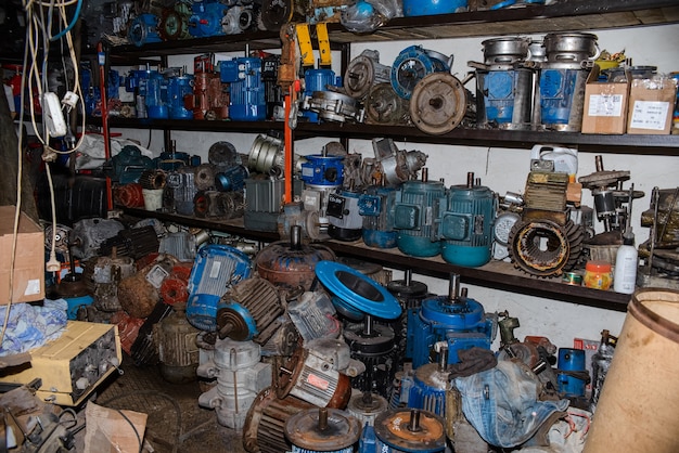 De nombreux moteurs électriques industriels cassés dans le garage sur rack. Matériel électrique en réparation, générateurs de courant asynchrones sales