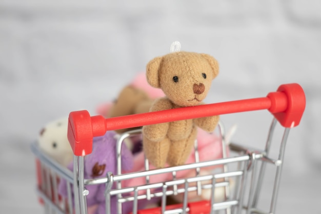 De nombreux ours en peluche jouets colorés se trouvent dans le panier d'épicerie. Faire ses courses au marché. Acheter des cadeaux pour les anniversaires et les vacances.