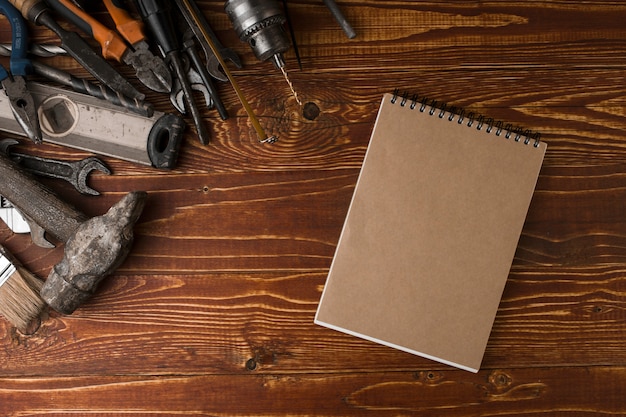 De nombreux outils pratiques et cahier sur la table en bois, vue de dessus