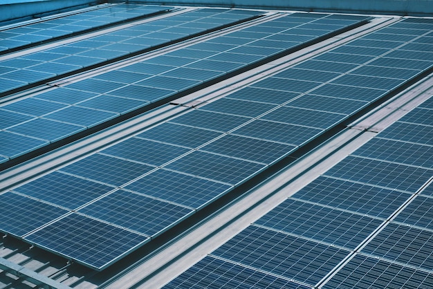 De nombreux panneaux solaires photovoltaïques montés sur le toit d'un bâtiment industriel