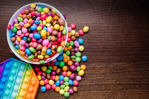 De nombreux petits bonbons colorés savoureux et pépin sur fond de bois